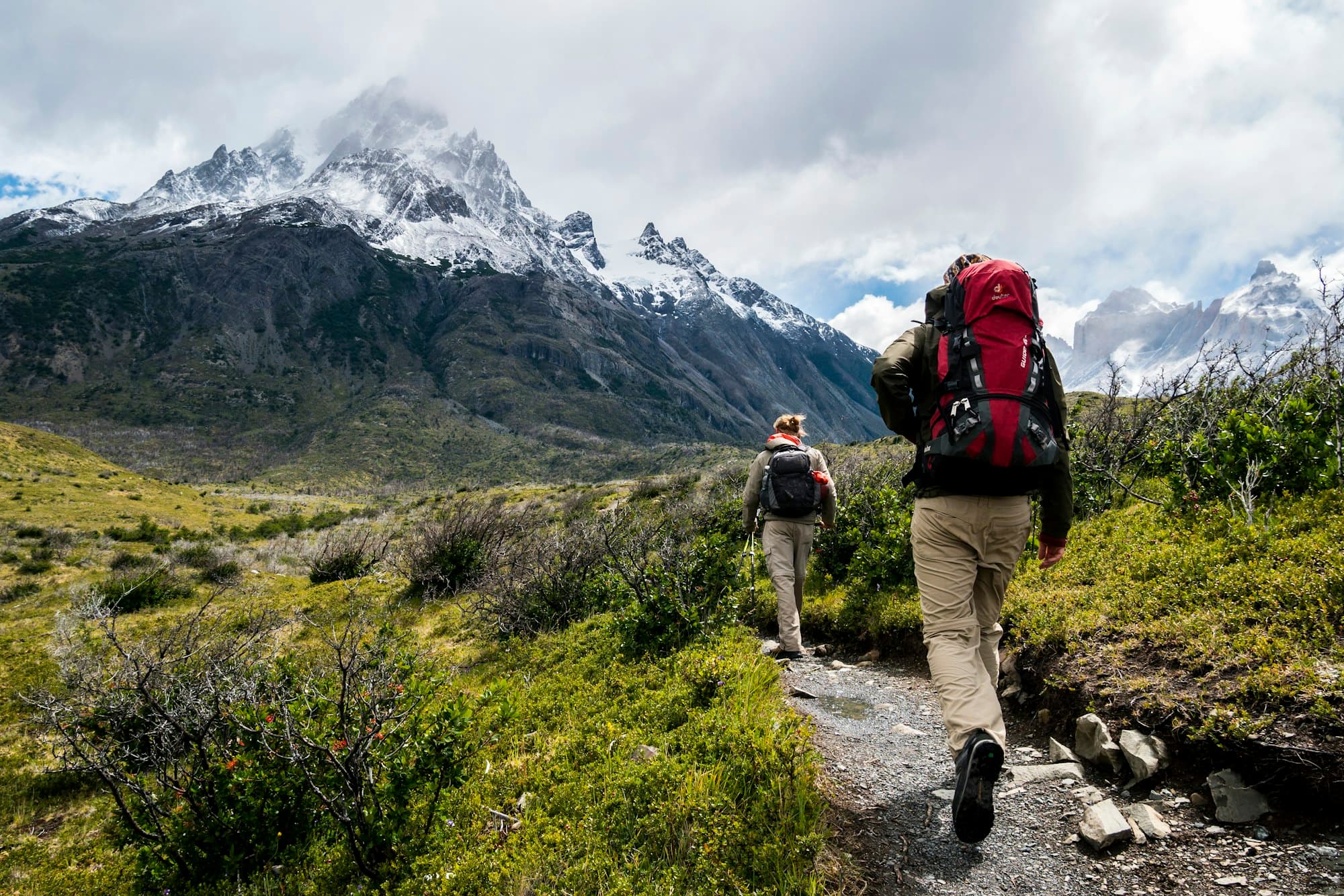 Friends seen from behind, arms around each other, looking across a valley